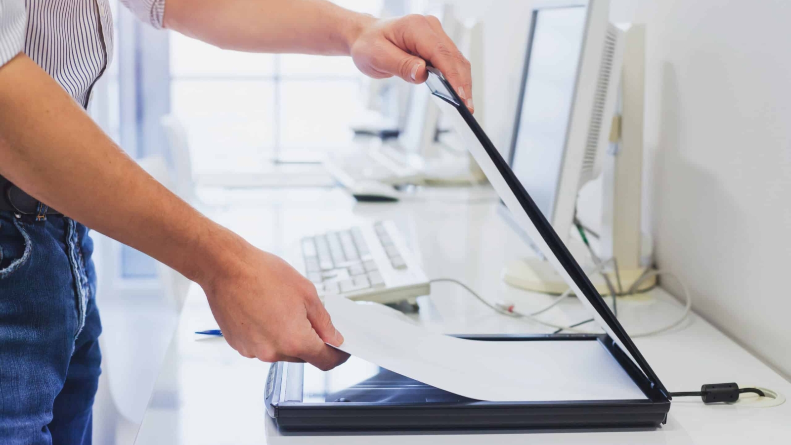 using scanner in office or library, closeup of hands scanning documents